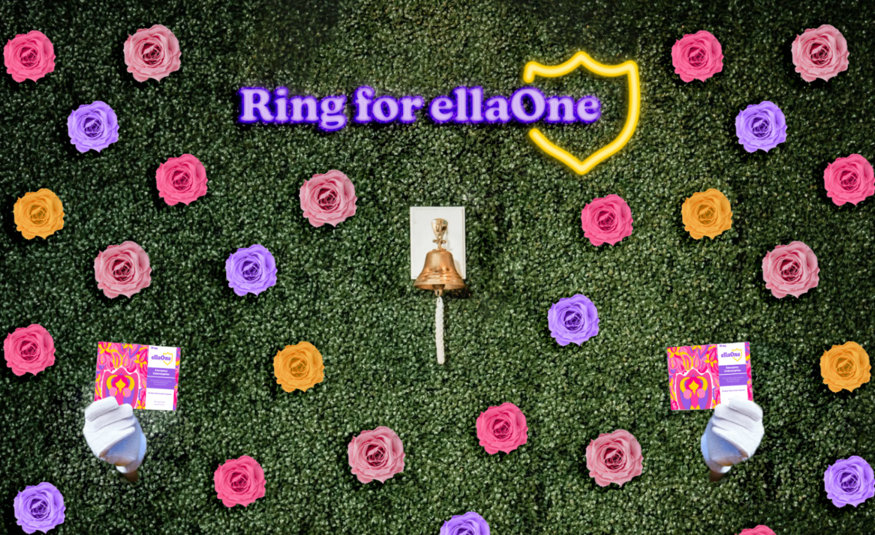 ellaOne mall pop-up hedge wall with neon shield and 'Ring for ellaOne' sign.